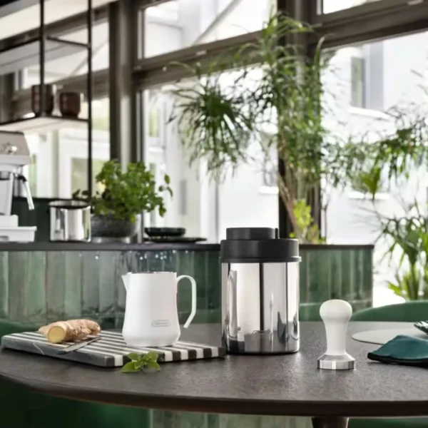 Vakuum posuda za čuvanje kafe DeLonghi, tamper i latijera za mleko na stolu