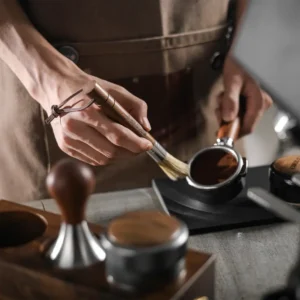barista čisti portafilter drvenom četkom